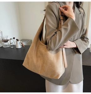 Detail of khaki suede tote bag showing adjustable strap and textured finish on a model