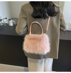 Close-up of pink faux fox fur crossbody bag with round handle in a cafe setting
