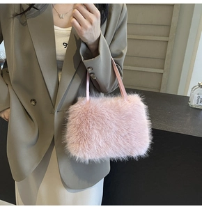 Close-up of pink faux fur plush handbag with thin straps shown on a fashion model
