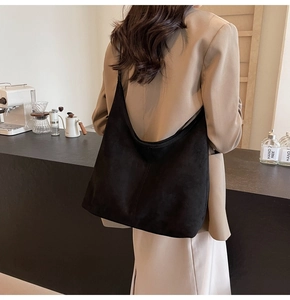 Macro detail of the high-quality black suede material and vertical stitching on this hobo bag