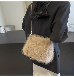 Detail of plush beige faux fur shoulder bag with slender leather strap and gold hooks