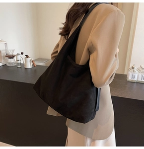 Detail of black faux suede tote bag showing large capacity and comfortable wide shoulder strap
