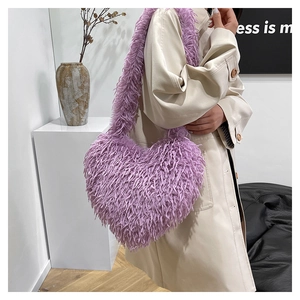 Détail d'un sac à épaule violet en fausse fourrure en forme de cœur sur un manteau