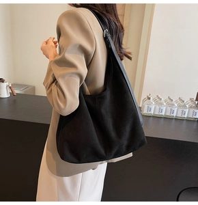 Close-up of black suede hobo bag showing adjustable strap and premium texture