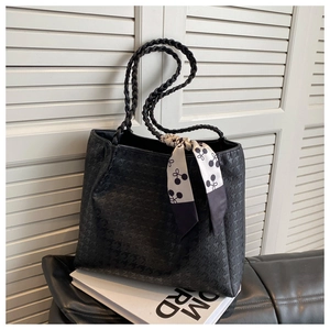Detail of black houndstooth embossed tote bag with cherry pattern silk scarf handle