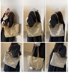 Detail view of the canvas tote bag showing printed typography and durable shoulder straps
