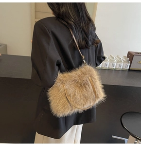 Detail of light brown faux fur handbag with leather strap and golden metal hooks
