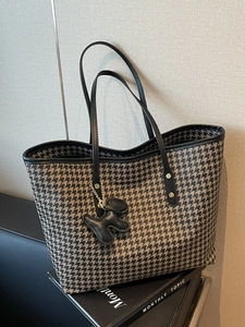 Classic houndstooth tote bag with black leather handles and dog charm accessory