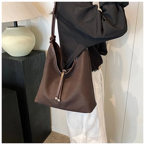 Macro detail of large brown shoulder bag with textured leather and drawstring closure