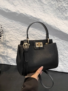 Retro black litchi grain leather handbag with a top handle and gold metal twist lock