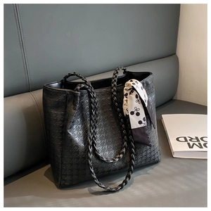 Detail of black houndstooth tote bag with braided handles and decorative silk scarf