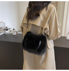 Close-up of black faux fur plush tote bag with leather strap on a beige trench coat