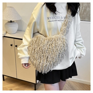 Gros plan détaillé du sac bandoulière en fausse fourrure en forme de cœur gris peluche