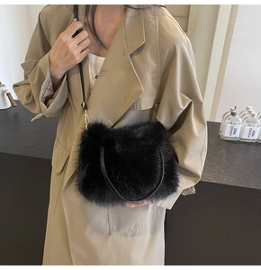 Detail of black faux fur crossbody bag with thin leather strap and gold hardware accents
