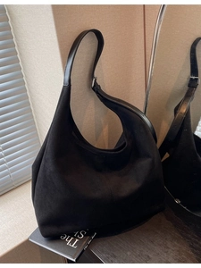 Retro black suede hobo shoulder bag with adjustable strap in minimalist room setting