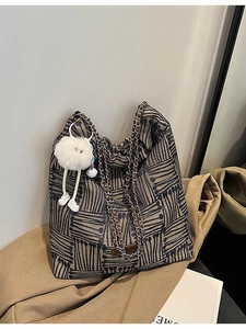 Striped jacquard tote bag with metal chain straps and a cute plush monster pendant