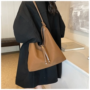 Detail of brown hobo bag featuring drawstring closure and unique knot shoulder strap