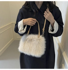 Detail of soft cream faux fur tote bag with adjustable leather strap and golden hardware