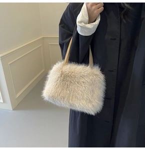 Detail of plush faux fur handbag in cream white featuring soft texture and stylish handles