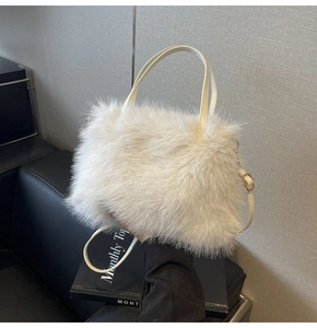 Detail of cream faux fur handbag with slim leather handles and adjustable shoulder strap