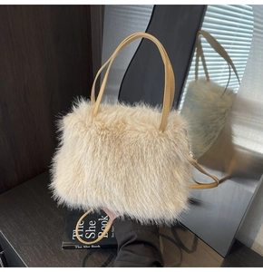 Chic cream faux fur handbag with leather handles shown in a modern home interior setting