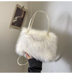 Detail view of a white faux fur handbag with leather straps and fluffy winter texture