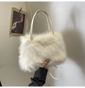 Close-up of fluffy cream faux fur handbag with slender matching handles for winter