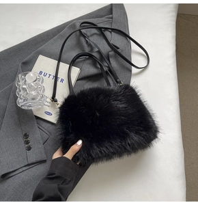 Detail view of black faux fur handbag on a grey suit with a cozy winter aesthetic
