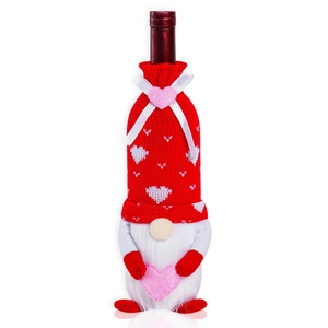 Detail of red and white knitted gnome wine bottle cover with heart pattern and white beard