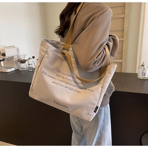 Close-up of canvas tote bag with brown straps in a cozy cafe setting during commute