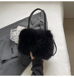 Close-up of black faux fur tote bag with leather straps on minimalist grey background