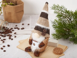 Detailed close-up of a coffee gnome figurine with a striped hat and tiny white coffee cup