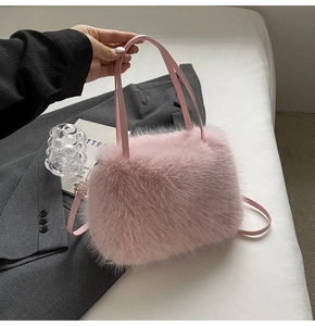 Detail of pink faux fox fur handbag showing soft texture and leather strap with gold clasp