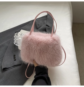 Detail of pink faux fur handbag with sleek leather handles and minimalist design texture