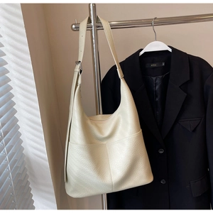 Detail der cremeweißen Leder-Einkaufstasche mit Kieselstruktur und verstellbarem Gurt