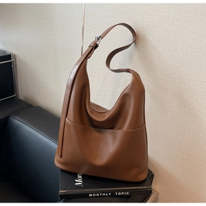 Detail der braunen Schultertasche aus Leder mit Ziernaht und silbernen Metallelementen