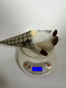 Detail showing a coffee-themed gnome plush ornament weighed on a white digital scale