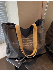 Minimalist canvas tote bag in charcoal grey with yellow straps for daily commuting
