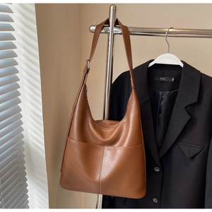 Detail einer braunen Hobo-Tasche aus Leder mit Lychee-Muster und verstellbarem Schultergurt