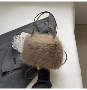 Detailed texture of brown faux fur handbag displayed on grey blazer with soft lighting