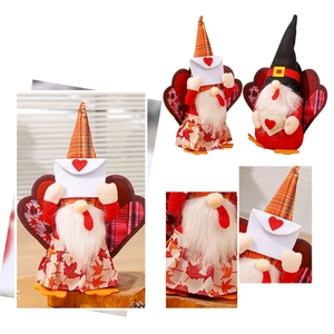 Dettaglio di gnomi di peluche con cappello a quadri arancione e motivi di foglie d'acero