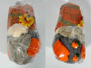 Detailed view of two autumn gnome plush toys with sunflowers and mini pumpkins