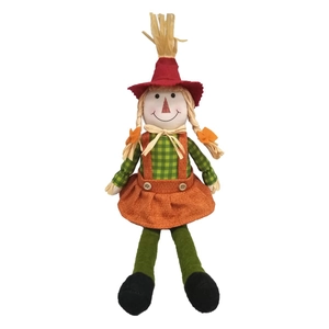 Close-up of harvest scarecrow doll with red hat and green plaid shirt details