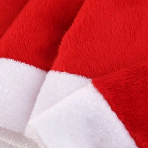 Macro detail of red and white plush fabric on mini Christmas bottle cap decorations
