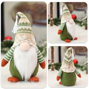 Close-up of green knitted Christmas gnome featuring long beard and tassel hat details