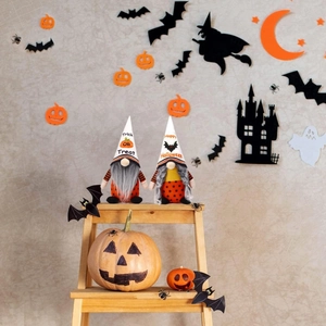 Halloween faceless gnomes set on wooden stand with Trick or Treat and spooky decorations