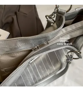 Macro shot of silver embossed tote bag with smooth metal zipper and chevron fabric lining