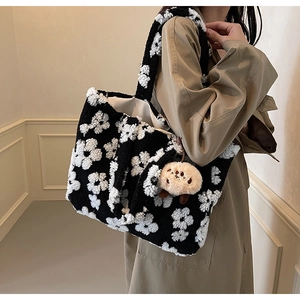Detail of plush floral tote bag with lamb wool texture and cute bear pendant accessory