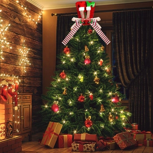 Detailed view of red and green elf hat Christmas tree topper with striped legs and bow