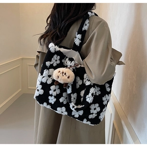 Detail of floral plush tote bag texture with cute round charm on a beige trench coat